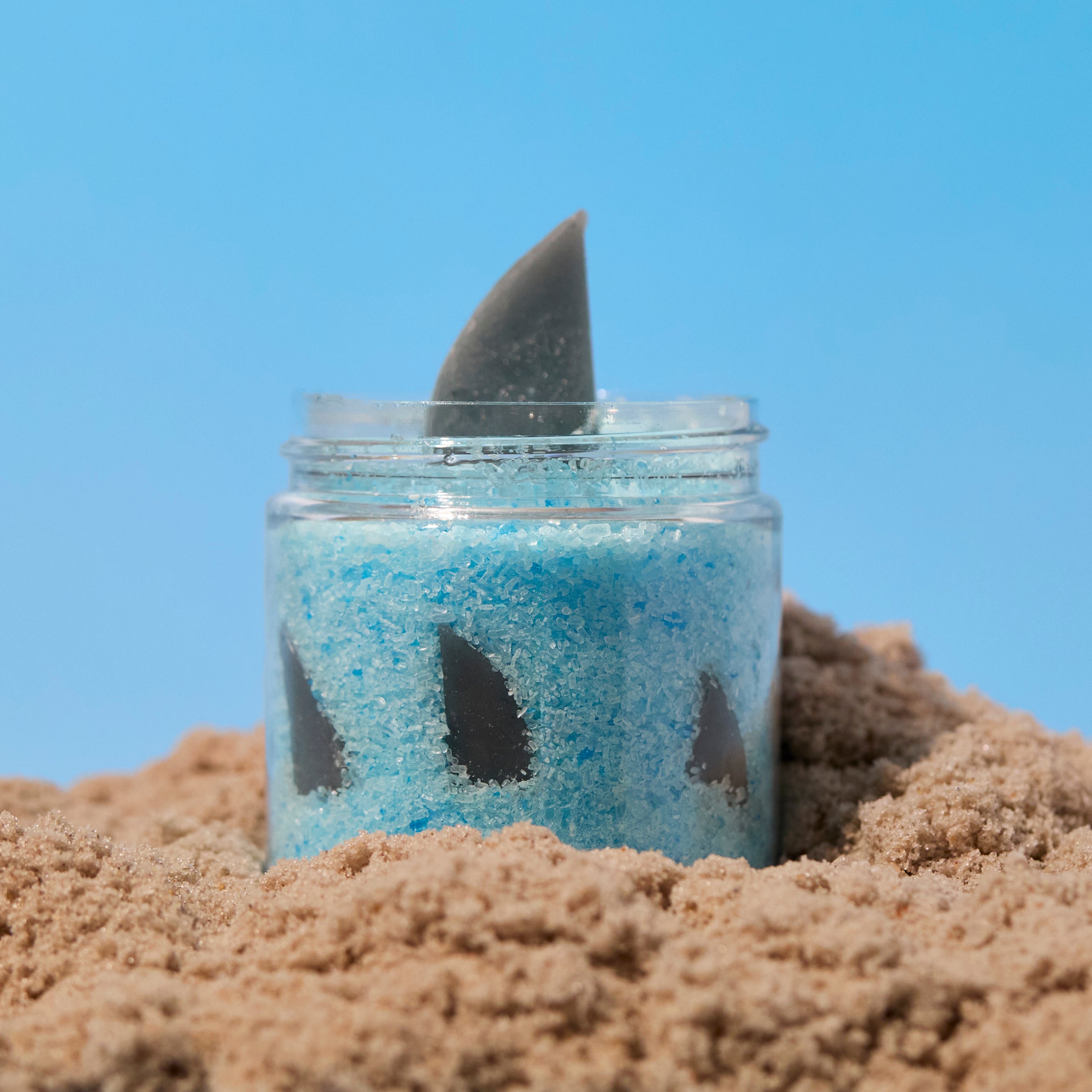 jar of blue bath salts with a shark fin sticking out