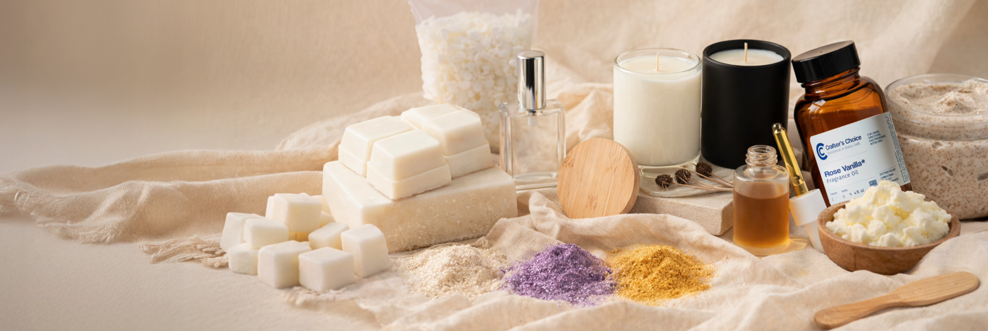 Neutral-toned display of soap making supplies including melt-and-pour soap cubes, fragrance oils, candles, shea butter, botanical powders, and a jar of scrub arranged on soft fabric for a clean, natural aesthetic.