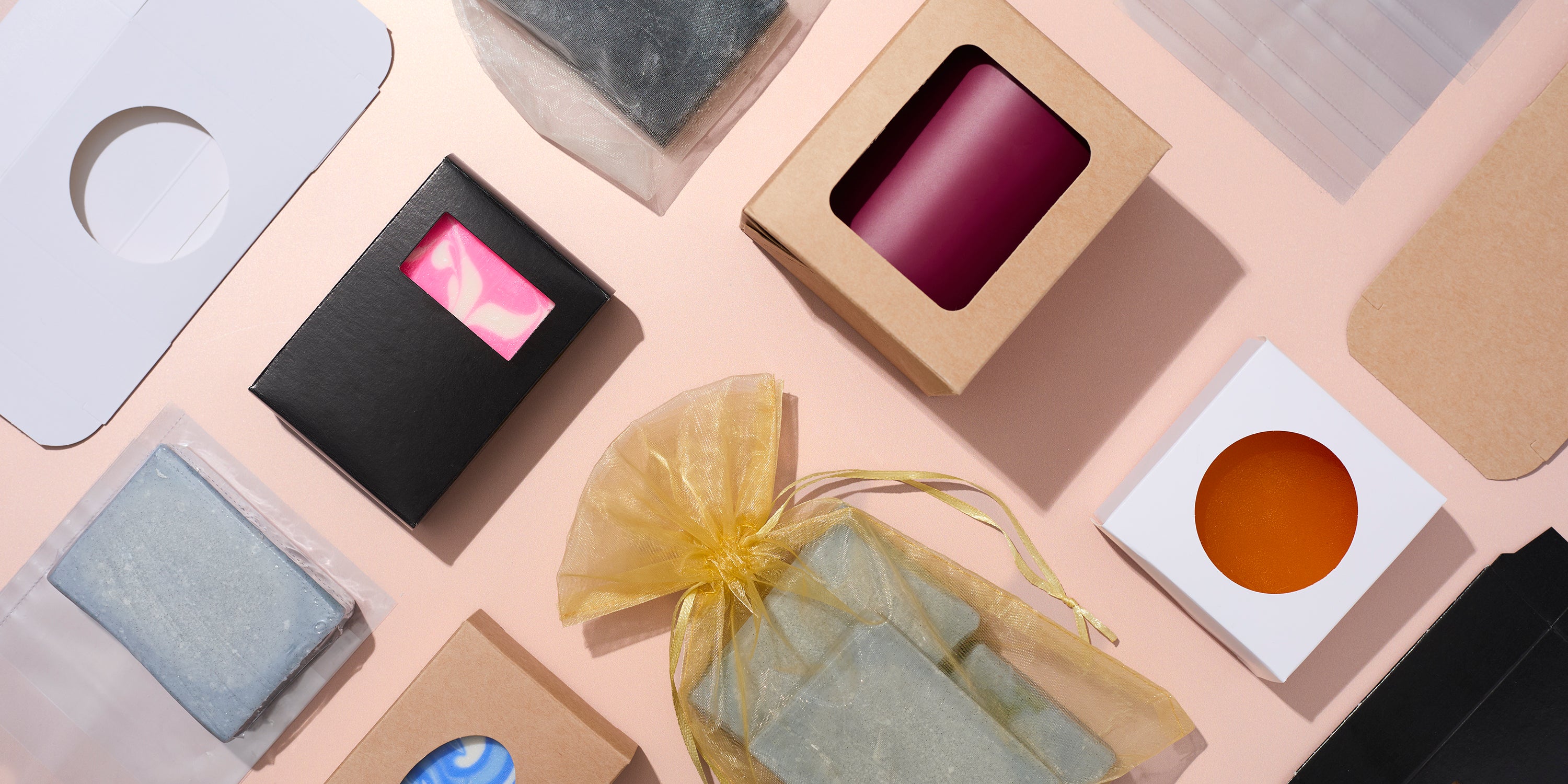 Collection of small boxes and packaging on a peach surface shot top down