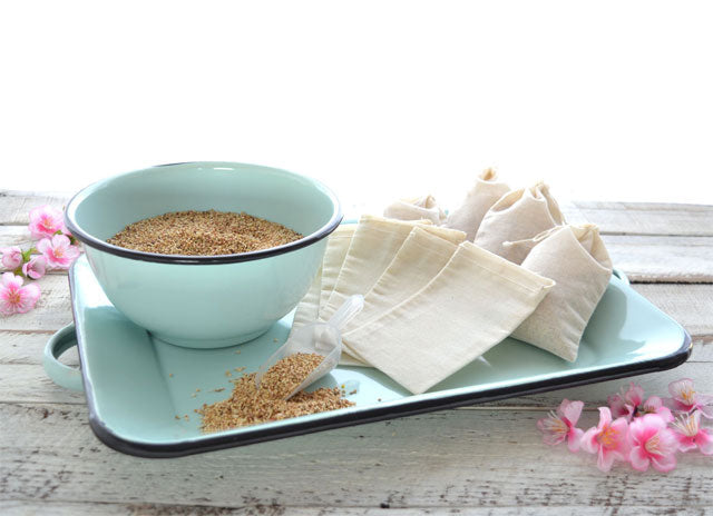 Fabric sachet bags beside a bowl of scented sachet base on a turquoise tray